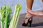 A girl with her pantys around her ankles and a stalk of celery.